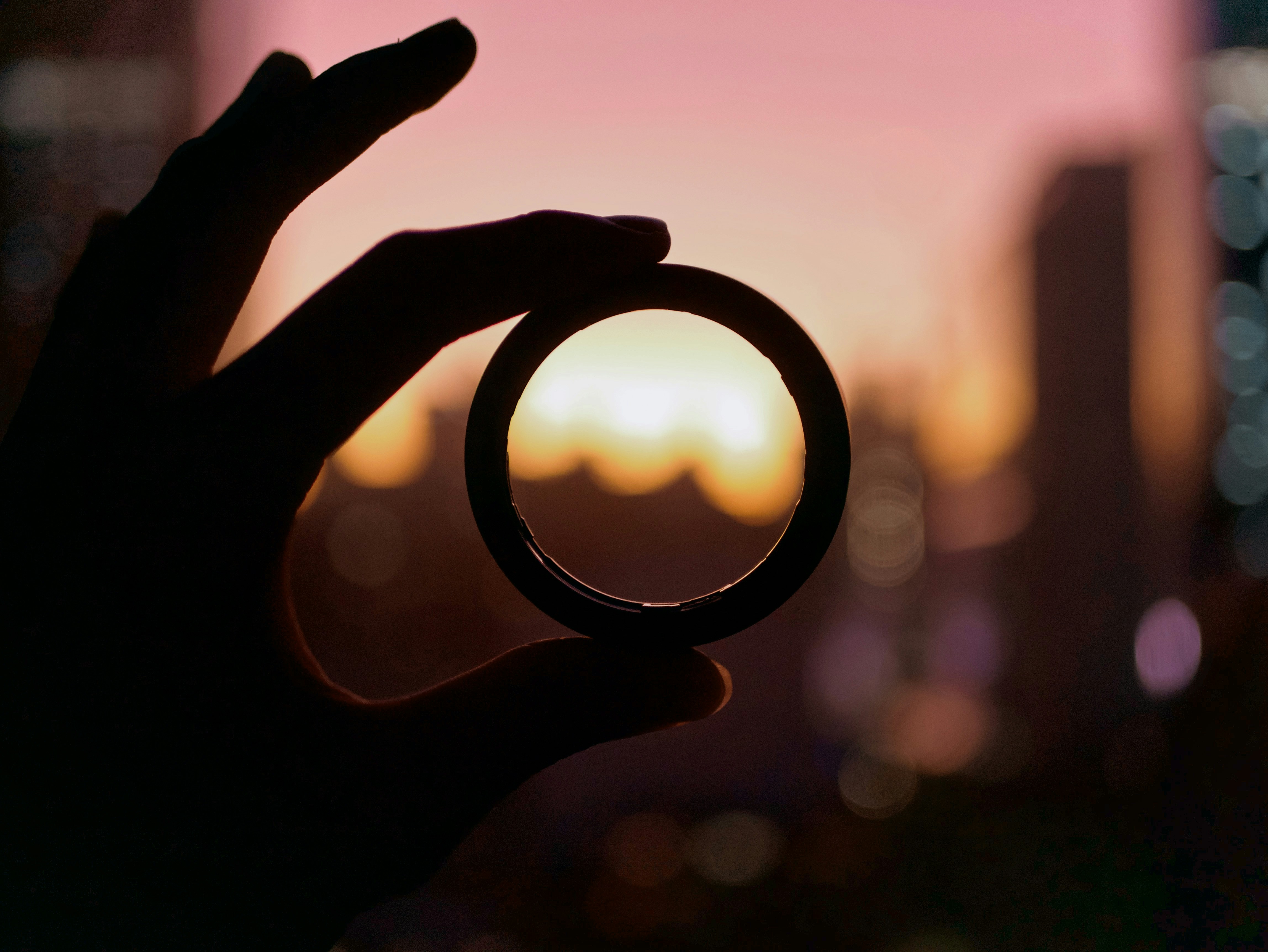 Une main tenant un cercle focal sur un horizon flou , illustrant le processus de recentrage, de focus et de clarté pour reprendre le contrôle de sa vie.